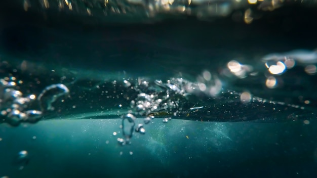 Vista subacquea di bolle d'aria che galleggiano in superficie nell'acqua di mare.