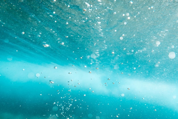 Vista subacquea di bolle nel mare blu profondo vicino sullo sfondo dell'acqua