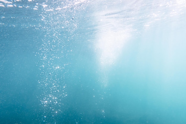 Vista subacquea di bolle nel mare blu profondo vicino sullo sfondo dell'acqua