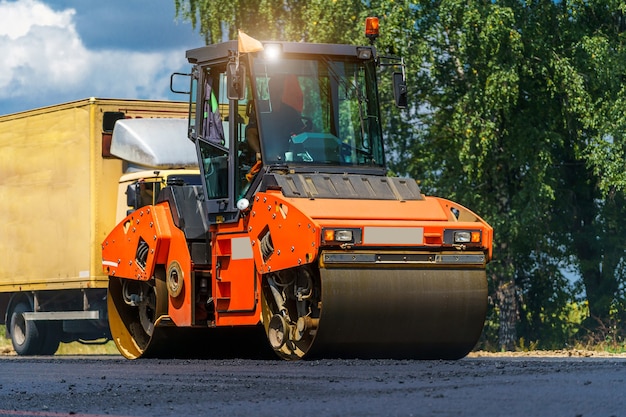 Vista sui rulli compressori al lavoro nel nuovo cantiere stradale. Fuoco selettivo sulla riparazione della strada. Avvicinamento