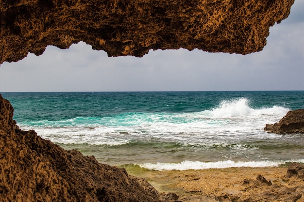 Vista sul mare attraverso la grotta in una giornata di sole.