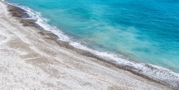 Vista sul mare blu con sabbia bianca e spiagge selvagge.