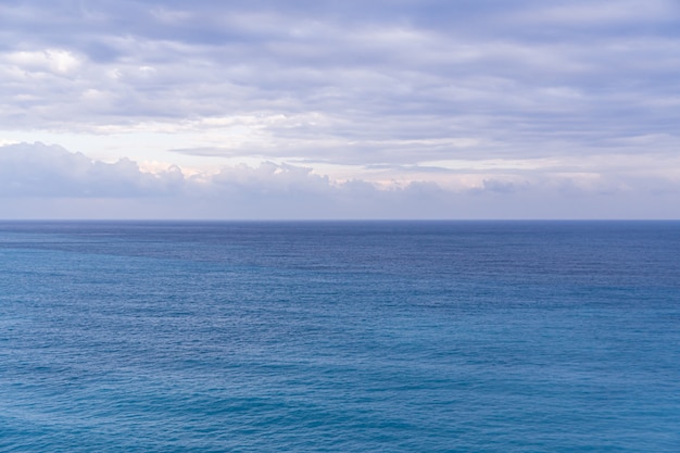 Vista sul mare con l'orizzonte del mare e cielo blu profondo quasi chiaro, fondo, spazio della copia