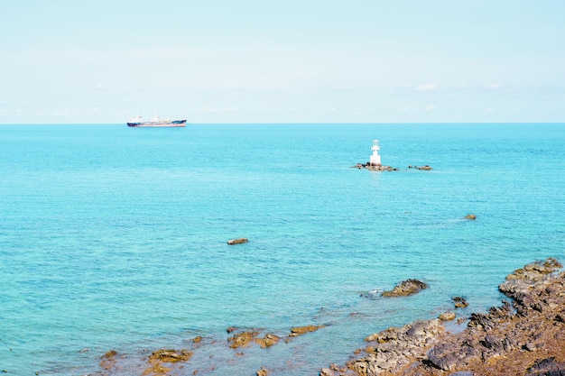 Vista sul mare del mare tropicale in Thailandia con un cielo blu e la torre del faro marittimo