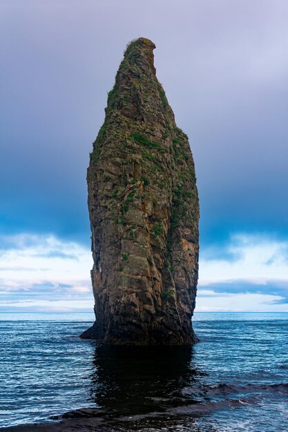 Vista sul mare della riva dell'oceano di Kunashir con un'enorme roccia verticale nell'acqua