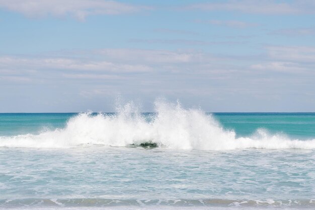 Vista sul mare della spruzzata dell'acqua con cielo blu sopra l'acqua del mare o dell'oceano, natura.