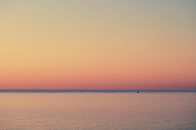 Vista sul mare di un bel tramonto dorato con spazio per la copia Sole che tramonta all'orizzonte di un oceano calmo al tramonto o al crepuscolo L'oceano o il mare calmo e tranquillo la sera con cielo luminoso copyspace