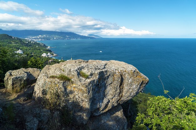 Vista sul mare e su Yalta dal sentiero soleggiato e da una grossa pietra a strapiombo. Crimea.