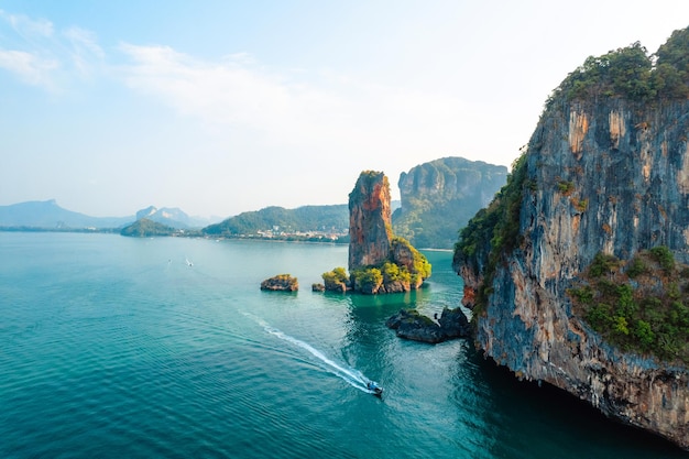 Vista sul mare e sulle isole rocciose con una barca a coda lunga