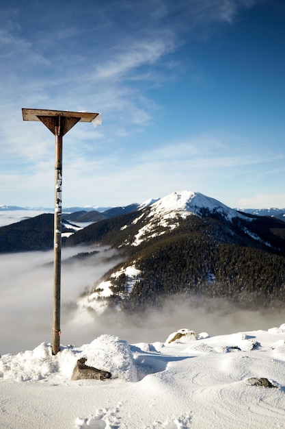 Vista sul Monte Sunyak sopra il mare di nebbia nelle montagne d'inverno Giornata di sole nella coperta di neve dei Carpazi Ucraina Nuvole sopra il cielo limpido