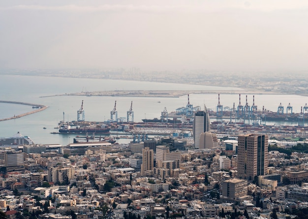 Vista sul porto di Haifa in Israele in una giornata nuvolosa. Parte industriale di Haifa con banchine e traghetti. Edifici di una città di mare. Attrazioni turistiche di Israele. Baia nel Mar Mediterraneo.