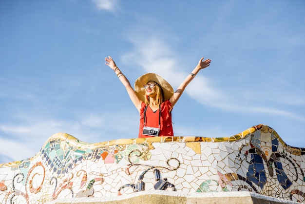 Vista sulla bellissima terrazza decorata con mosaico con una turista felice nel parco Guell a Barcellona