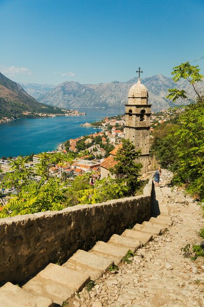 Vista sulla chiesa, antiche mura, montagne e mare nella città vecchia di Kotor. Montenegro, Baia di Kotor. Vista dall'alto