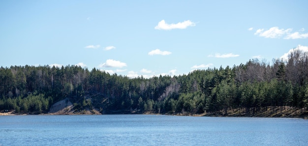 Vista sulla natura con lago blu, alberi verdi e cielo blu