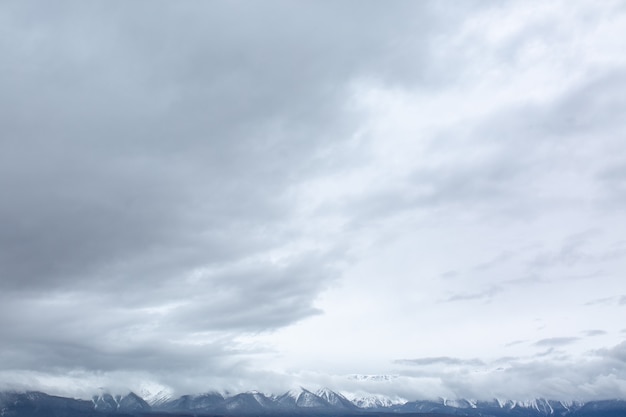 Vista sulle montagne innevate con tempo nuvoloso