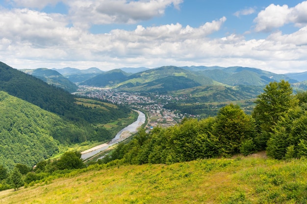 Vista sulle montagne sulla valle con il villaggio tra le montagne. Vista esterna della natura di estate dal picco