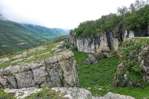 Vista sulle montagne tra le nuvole e l'ingresso alla ciotola di pietra Daghestan Russia