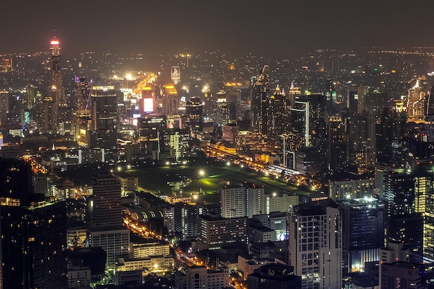 Vista sullo skyline e percorsi di luce delle auto dalla cima del King Power Mahanakhon di notte