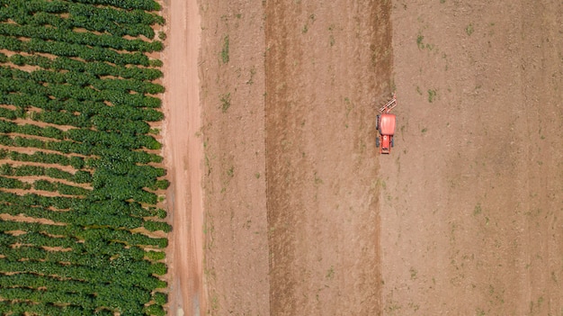 Vista superiore dei veicoli del trattore agricolo che lavorano al campo