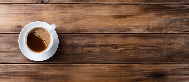 Vista superiore del caffè caldo in una tazza bianca su un tavolo di legno