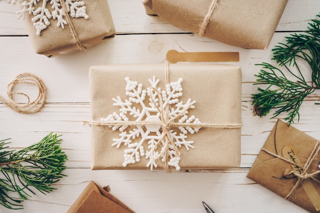 Vista superiore del contenitore di regalo e della cartolina di Natale sulla tavola di legno con la decorazione di natale.