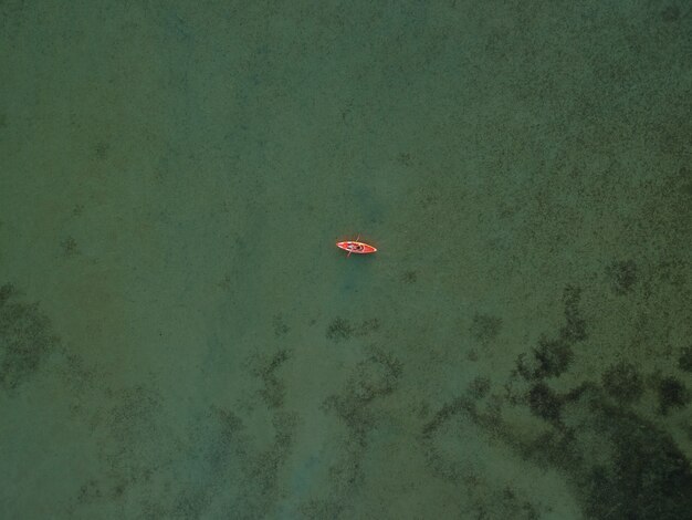 Vista superiore della barca del kajak sull'acqua bassa del turchese del mare di Azov, Ucraina