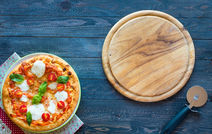Foto vista superiore della classica pizza italiana margherita su un tavolo di legno con condimenti