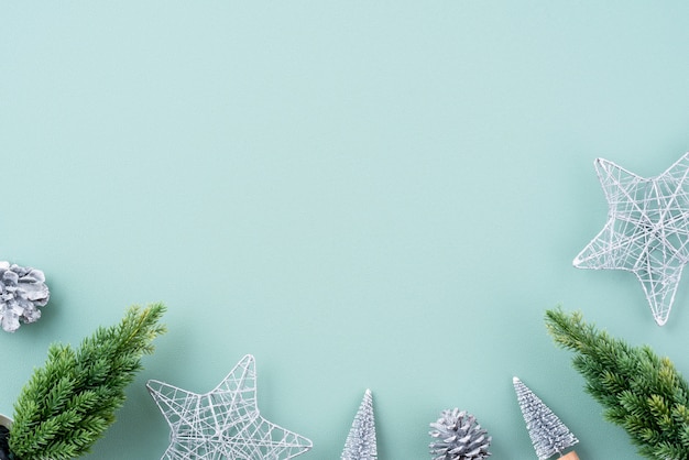 Vista superiore della composizione dell'ornamento della decorazione di festa di Natale con la disposizione piana dell'uomo di Pan di zenzero della stella del regalo dell'albero di Natale con lo spazio della copia isolato su fondo verde