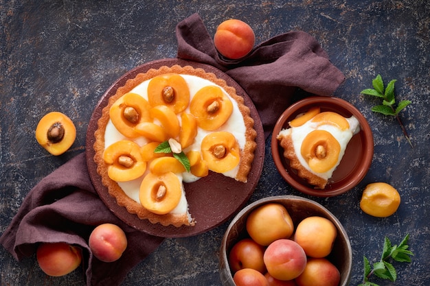 Vista superiore della crostata di albicocche con foglia di menta sulla parete strutturata scura