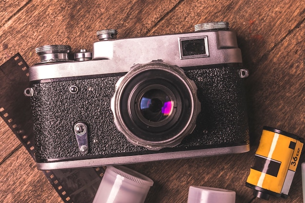 Vista superiore della macchina fotografica d&#39;epoca e film sul tavolo di legno