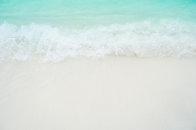Vista superiore della sabbia e della spiaggia pulita dell'acqua e della sabbia bianca di estate con il cielo blu-chiaro del sole e il fondo del bokeh.