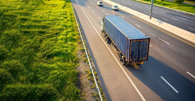 Vista superiore della sfuocatura di movimento del camion bianco sulla strada della strada principale con il contenitore, concetto del trasporto.