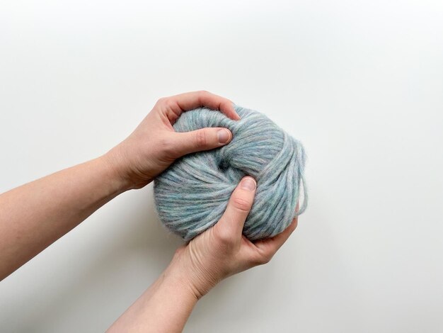 Vista superiore di donne con le mani che tengono un grande asciugamano di lana blu per la maglieria Supplies per hobby di maglieria