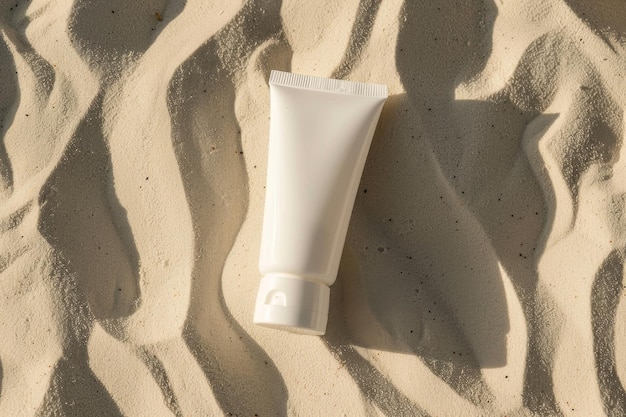 Vista superiore di un modello bianco di un tubo di crema sulla sabbia