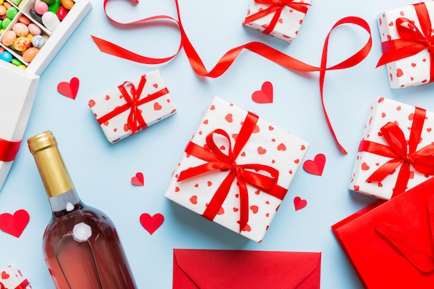 vista superiore foto di st valentine day decor shopping bag bottiglia di vino busta regalo scatola caramelle e cuore rosso su sfondo colorato con spazio vuoto sfondo telaio