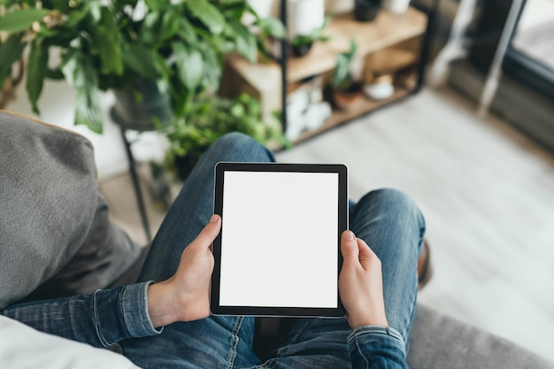 vista tagliata di un uomo che tiene in mano un tablet digitale con uno schermo vuoto a casa