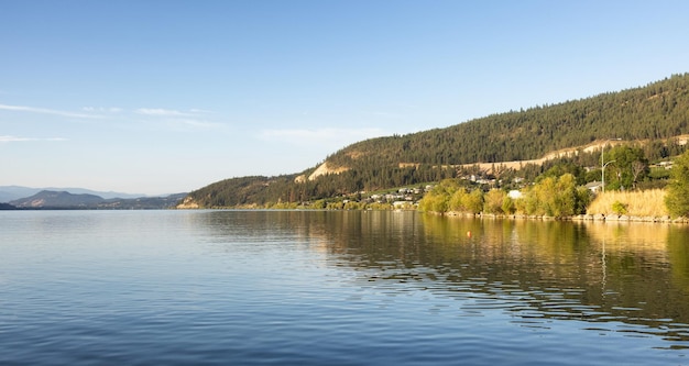 Vista tranquilla del lago di legno con la riflessione sull'acqua e le montagne sullo sfondo