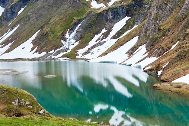 Vista tranquilla di estate delle montagne delle Alpi, riflessioni sul lago vicino alla strada alpina del Grossglockner