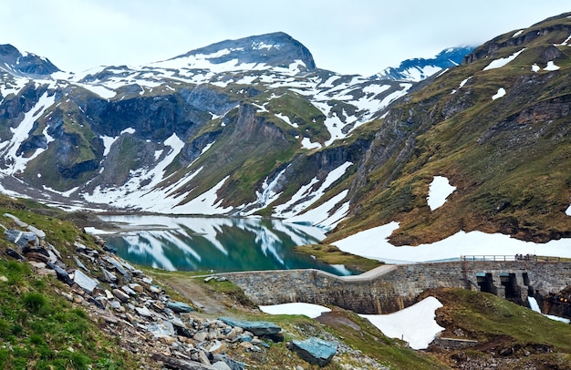 Vista tranquilla di estate delle montagne delle Alpi, riflessioni sul lago vicino alla strada alpina del Grossglockner