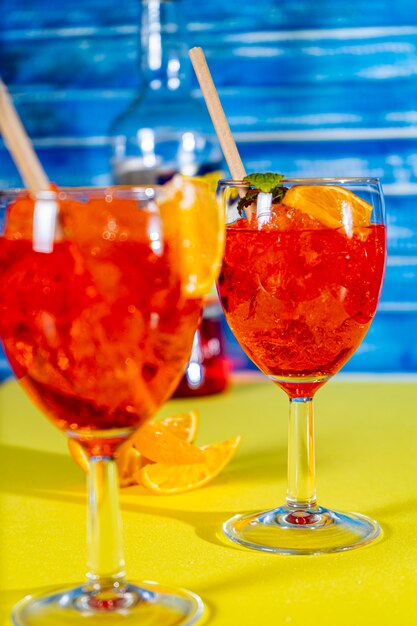 Vista verticale di due bicchieri del rinfrescante cocktail aperol spritz con menta