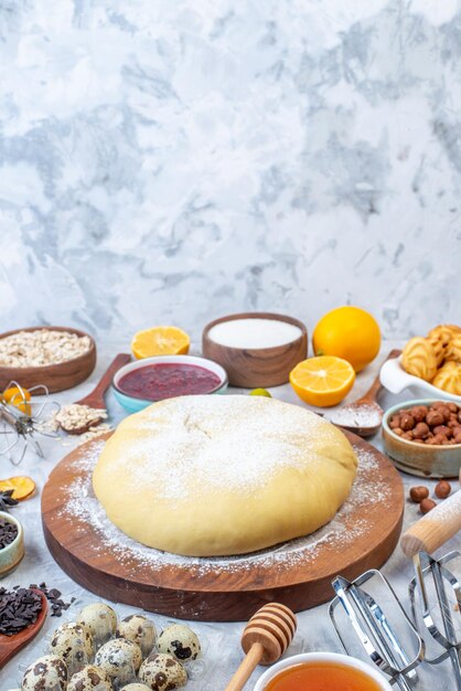 Vista verticale di pasticceria cruda e set di vari alimenti grattugia su sfondo di ghiaccio