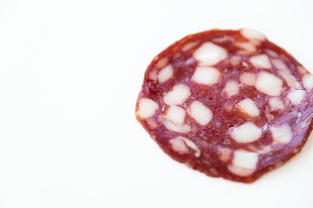 Viste dall'alto e laterale delle fette di salsiccia affumicata isolate su sfondo bianco