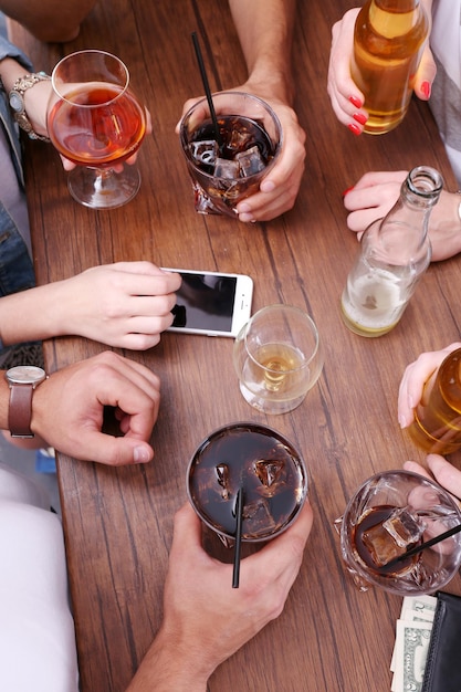 Visualizza gli amici che bevono bevande alcoliche nel primo piano del bar