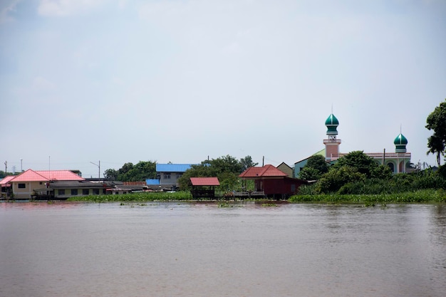 Visualizza il paesaggio e il fiume Chao Phraya con la casa del villaggio e l'antica moschea vintage retrò o masjedm o musjid nella città di Pathumthani lungo il fiume mentre scorre l'acqua a nord in Pathum Thani Thailandia