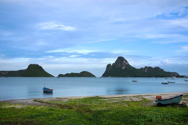 Visualizza il paesaggio marino e la barca da pesca in legno che galleggia in mare in attesa di catturare pesci e vita marina mentre la notte nell'oceano della spiaggia della baia di Prachuap nel Golfo di Thailandia a Prachuap Khiri Khan Thailandia