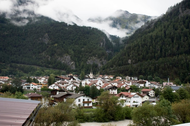 Visualizza il paesaggio urbano e il paesaggio della città di Pfunds con la chiesa di Lourdeskapelle al mattino e piove in Tirolo Austria