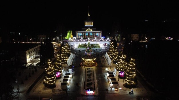 Visualizza la costruzione della giostra dei bambini degli alberi di Natale e la pista di pattinaggio sul ghiaccio all'aperto