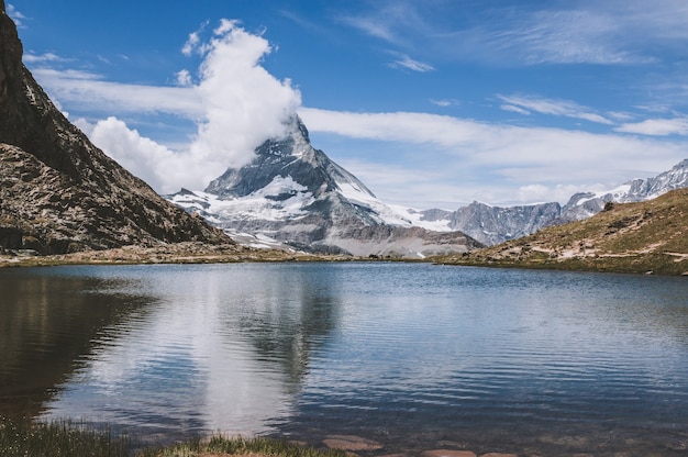 Visualizzare il primo piano del lago Riffelsee e del monte Cervino, scene nel parco nazionale di Zermatt, Svizzera, Europa. Paesaggio estivo, tempo soleggiato, cielo azzurro drammatico e giornata di sole