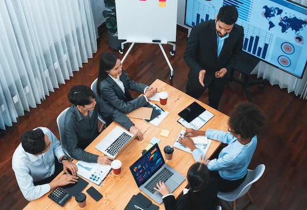 Visualizzazione superiore della presentazione aziendale con dashboard di analisi dei dati sullo schermo TV in una moderna sala riunioni Persone d'affari che fanno brainstorming o lavorano insieme per pianificare la strategia di marketing aziendale Concord