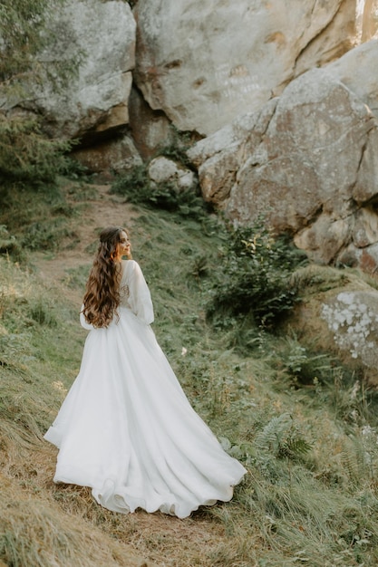 vita felice elegante ragazza tenera capelli neri bianco elegante vestito leggero, la signora corre nella foresta